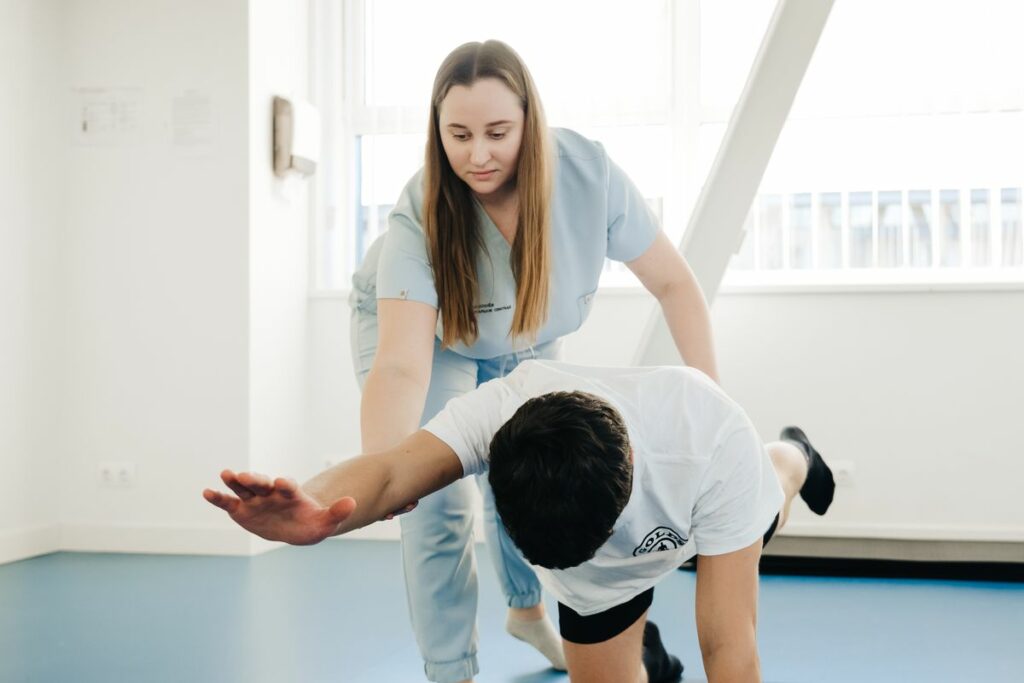 Ostéopathie et physiothérapie complémentaires : un thérapeute aide un patient lors d’un exercice d’étirement